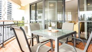 ein Esszimmer mit einem Tisch und Stühlen auf dem Balkon in der Unterkunft Victoria Square Apartments in Gold Coast