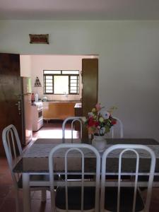 een eettafel met 2 stoelen en een vaas met bloemen bij chácara legal in Socorro