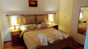 1 dormitorio con 1 cama grande y toallas. en Rincon del Beagle en Ushuaia