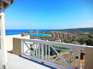 a view of the ocean from the balcony of a house at Columbus Heights Apt 26 F in Ocho Rios