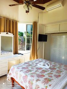 ein Schlafzimmer mit einem Bett mit einer Kommode und einem Fenster in der Unterkunft Columbus Heights Apt 26 F in Ocho Rios