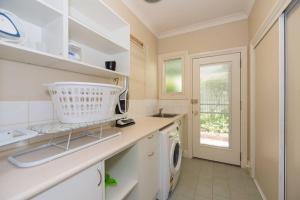 a kitchen with a sink and a washing machine at Wandew - Echuca Holiday Homes in Echuca
