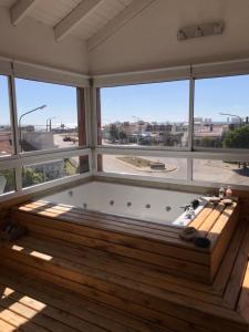 a jacuzzi tub in a room with large windows at Complejo Bahia Ballenas in Rawson