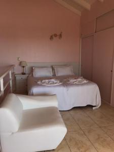 a bedroom with two white beds and a couch at Complejo Bahia Ballenas in Rawson