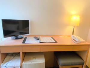 a desk with a monitor, keyboard and mouse on it at Sakura Hotel Hatagaya in Tokyo