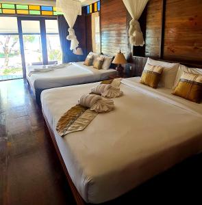 two large beds in a room with windows at Thanya Beach Resort - SHA Plus in Ko Ngai