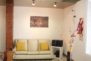 a living room with a couch and a painting on the wall at Hotel Catedral San Rafael in San Rafael