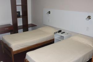 a room with two beds and a night stand at Hotel Catedral San Rafael in San Rafael