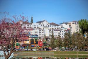 a city with buildings and trees and a pond at TTC Hotel - Ngoc Lan in Da Lat