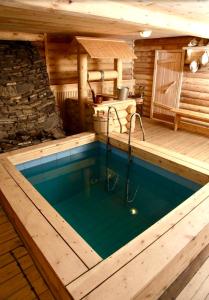 a swimming pool with a tub and a chair in it at Baikal Seasons Hotel in Listvyanka
