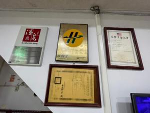 uma parede com certificados e placas numa parede em Da Fang Hotel em Jiaoxi