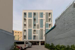 a tall building with cars parked in front of it at iHotel Uptown BGC in Manila