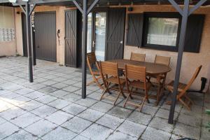 Une table et des chaises en bois sont disponibles sur la terrasse. dans l'établissement Portiragnes Plage PSD04, à Portiragnes