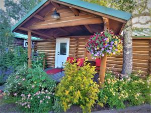 a wooden cabin with a bunch of flowers at Log Cabin Motel in Pinedale