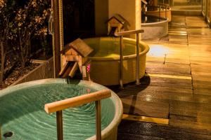 a jacuzzi tub with birdhouses in a room at Hakone Yumoto Onsen Hotel Kajikaso in Hakone
