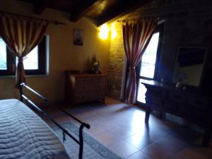 a bedroom with a bed and a dresser and windows at Agriturismo La Valle Incantata Gerace - in Gerace