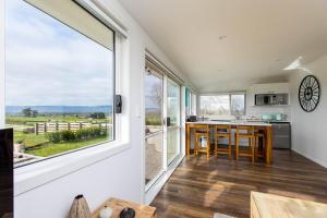 a kitchen with a large window and a kitchen island at Peria Hills Cottage in Matamata