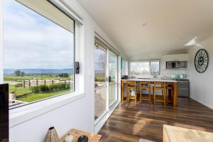 une cuisine avec une grande fenêtre et un îlot de cuisine dans l'établissement Peria Hills Cottage, à Matamata