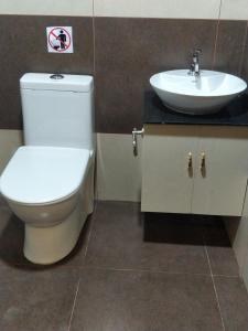 a bathroom with a toilet and a sink at Majestic Inn in Trivandrum