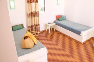 a room with two beds and a wooden floor at Arokaria Seaside in Ambelas
