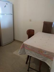 a kitchen with a table and a refrigerator at Between the Airport and the Harbour in Mytilini
