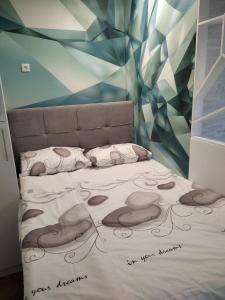 sypialnia z łóżkiem z malowidłem ściennym w obiekcie Apartman Lana w mieście Bijeljina
