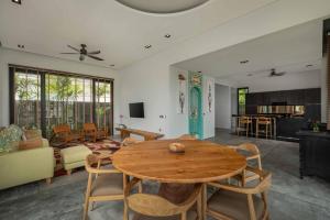 Cahaya Villa Canggu By Island Escape في تشانغو: غرفة معيشة مع طاولة وكراسي خشبية