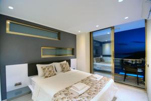 a bedroom with a large bed and a balcony at Villa Ahiska in Kalkan