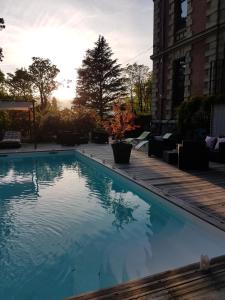 a swimming pool with the sun setting in the background at le château des arènes in Gières