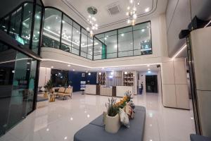 a lobby of a building with tables and chairs at Poolrada Boutique Hotel - SHA Plus in Thalang