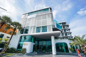 un edificio con palme di fronte di Poolrada Boutique Hotel - SHA Plus a Thalang