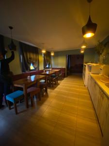 un ristorante con tavoli e panche in legno e luci di Hostel Zolota Nyva a Chortkiv