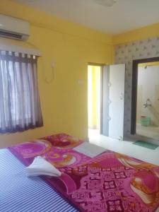 a bedroom with a bed with a purple blanket at Zeromiles Hotel Prasant in Digha