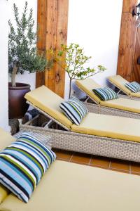 a row of benches with pillows on a patio at El Charco Suites in Arrecife