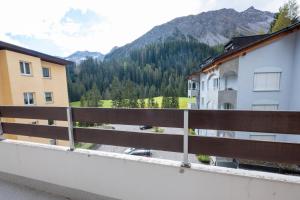 - un balcon offrant une vue sur les bâtiments et la montagne dans l'établissement Casa Irmella 12 - Arosa - alles komplett, à Arosa 3 autres photos