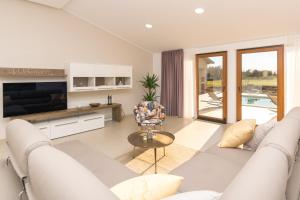 ein weißes Wohnzimmer mit einem Sofa und einem Tisch in der Unterkunft Relaxing pool villa Mattuzzi in Loborika in Loborika