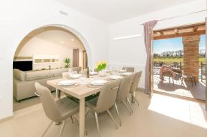 a white dining room with a table and chairs at Relaxing pool villa Mattuzzi in Loborika in Loborika