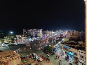 une rue animée de la ville la nuit avec des lumières dans l'établissement Hotel Vip Square, à Purî
