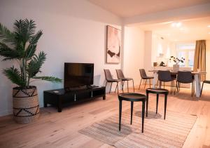 Smartflats - Antwerp View في أنتويرب: غرفة معيشة مع تلفزيون وطاولة وكراسي