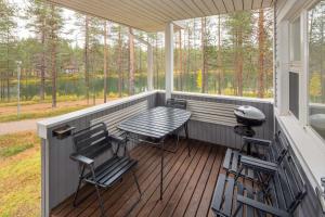 クーサモにあるHoliday Club Kuusamon Tropiikki Apartmentsのポーチ(椅子、テーブル、グリル付)