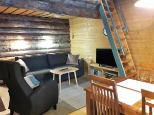 a living room with a couch and a television at Salmikangas G4 in Ruka