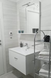 a white bathroom with a sink and a mirror at Apartment Janja in Medulin +11 photos