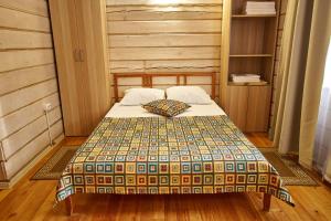 a bedroom with a bed with a quilt on it at Altay Park Hotel Podgoritsa in Manzherok