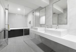 a bathroom with two sinks and two mirrors at Trans Inn in Taichung