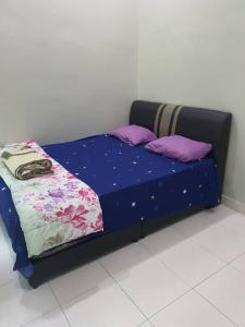 雙溪大年的住宿－Homestay LOT 88 Sungai Petani，一张床上的床铺,上面有紫色枕头