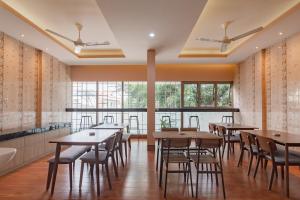 a dining room with tables and chairs and windows at RedDoorz Plus @ Cirebon City Center in Cirebon