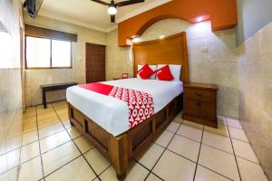 1 dormitorio con 1 cama grande con almohadas rojas en Hotel Romo, en Los Mochis