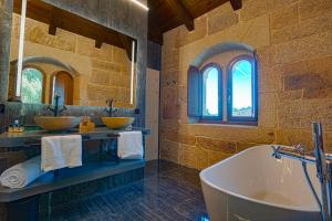 a bathroom with two sinks and a bath tub at Hotel As Torres da Hermida in Monterroso