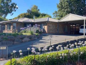 une maison avec des fleurs devant elle dans l'établissement Adelaide Hills Escape, à Woodside