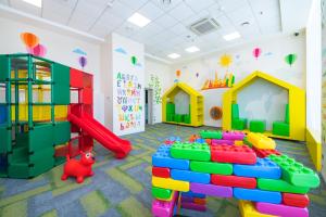 a childrens play room with a slide and play equipment at Omega Sirius in Adler